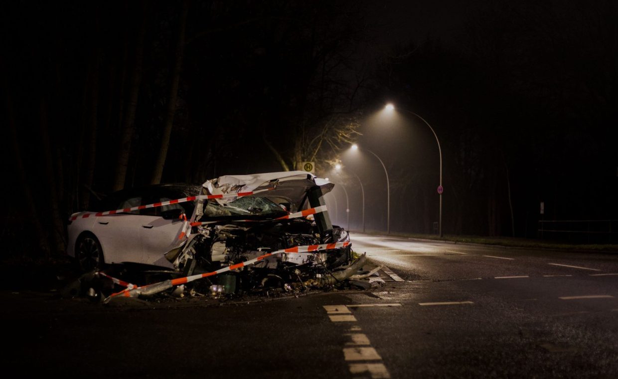 A wrecked car after a crash on a dimly lit street in Berlin at night.