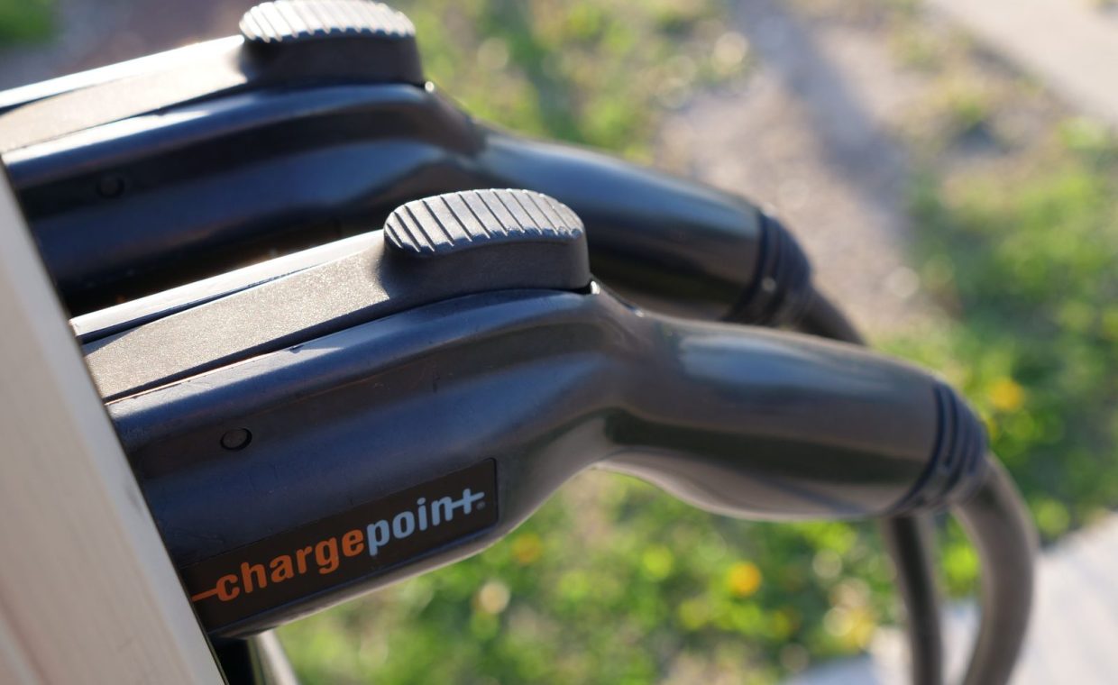 Detailed view of ChargePoint electric vehicle charging plugs at a station outdoors.