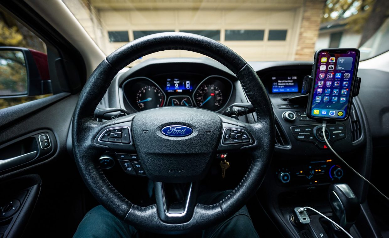 Interior view of a Ford car featuring a steering wheel, dashboard, and mobile device mount.