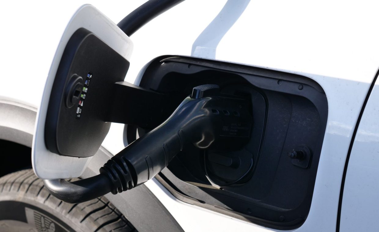 Close-up view of an electric vehicle charging with a focus on the connector and charging port.