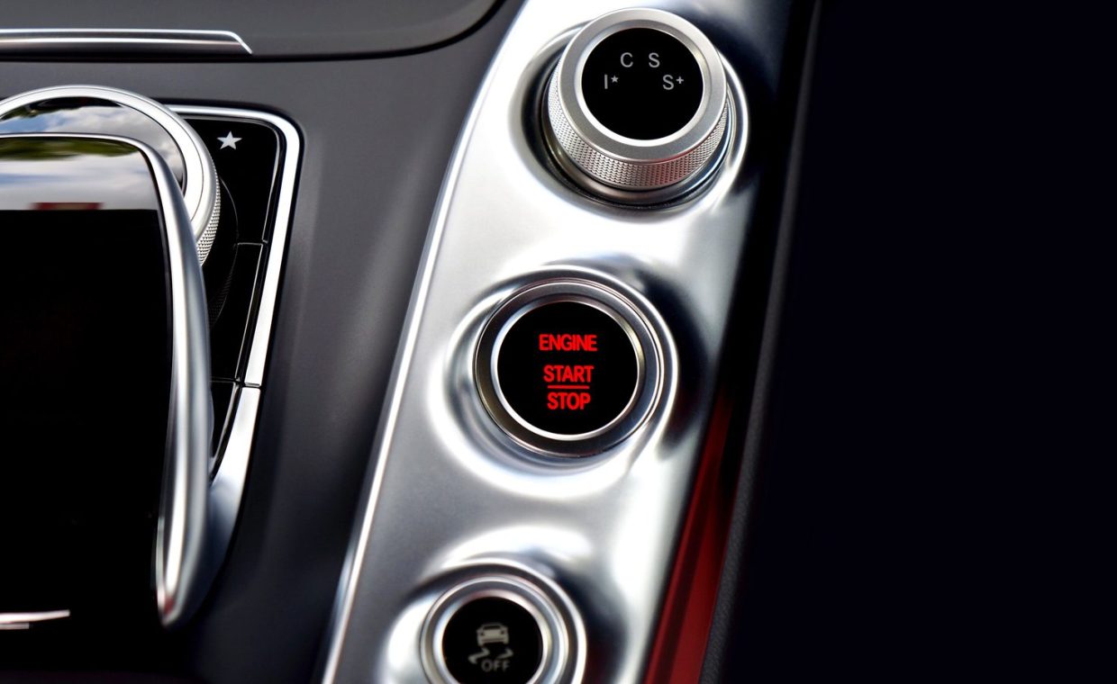 Close-up of a modern Mercedes car interior featuring a start-stop button and control panel.