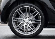 Detailed shot of a sleek car wheel and rim on a black vehicle, showcasing automotive design.