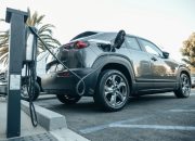 Modern electric vehicle charging at an outdoor station in daylight.
