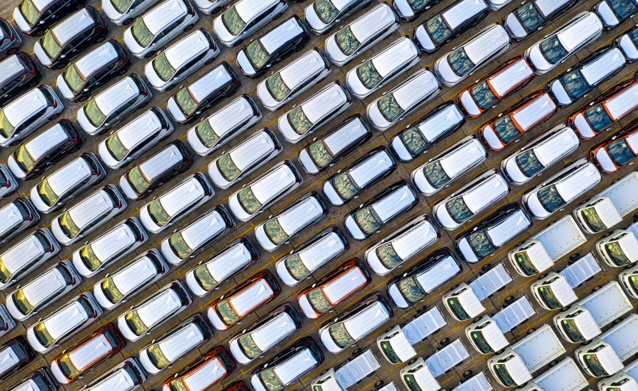 Aerial shot of neatly parked cars in a Jakarta industrial parking lot, showcasing symmetry and pattern.
