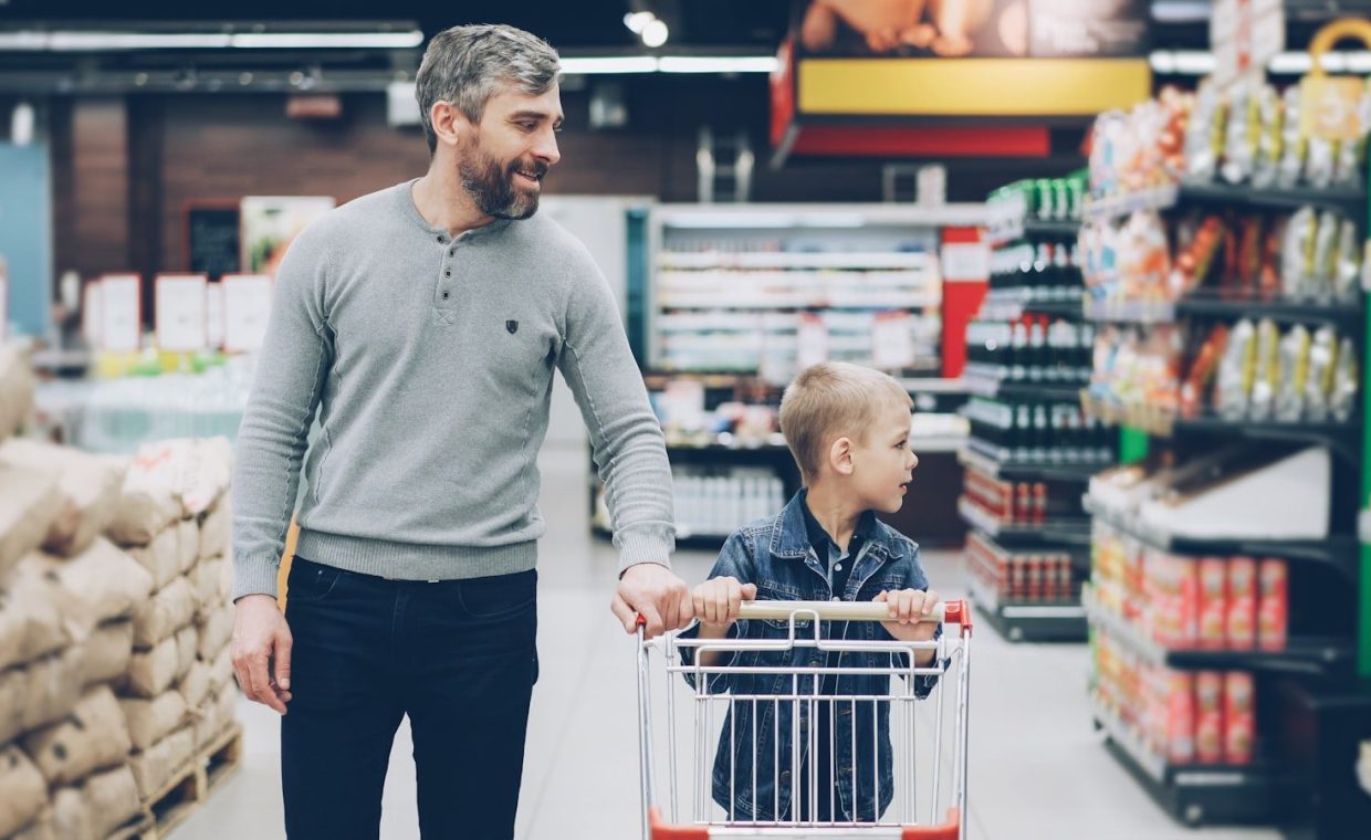 A father and son shop together in a supermarket.