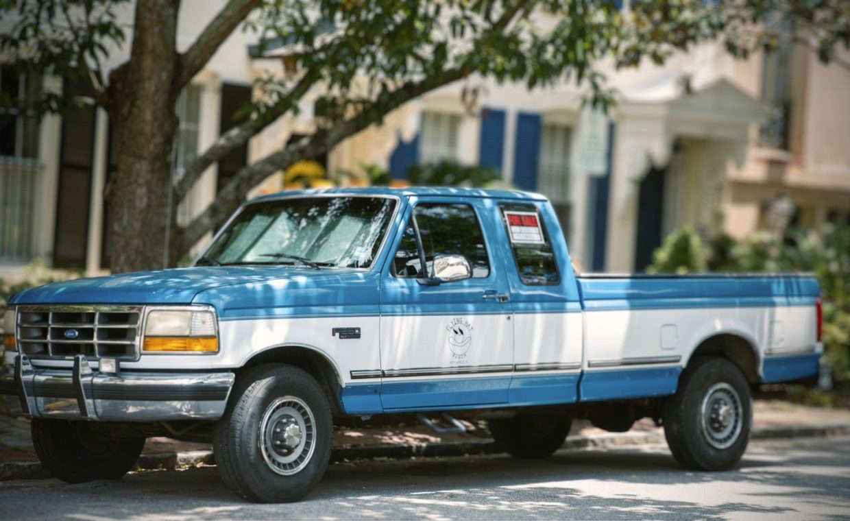 a blue truck parked on the side of the road
