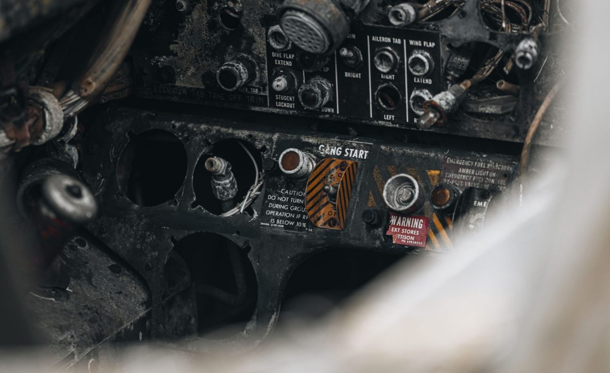 Close-up of a vintage aircraft's corroded and dirty cockpit control panel showcasing wear and rust.