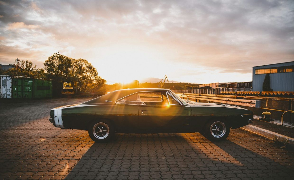 black coupe parked on brown brick floor during sunset