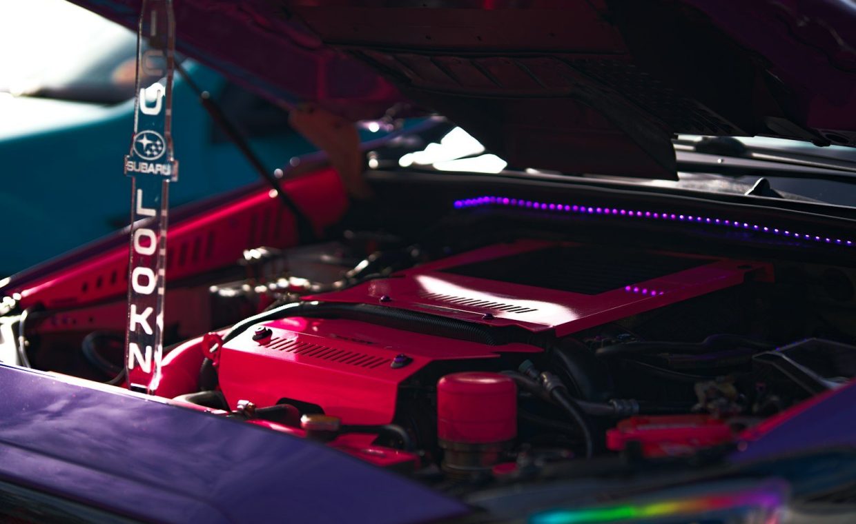 Pink custom engine bay illuminated by purple led lights.