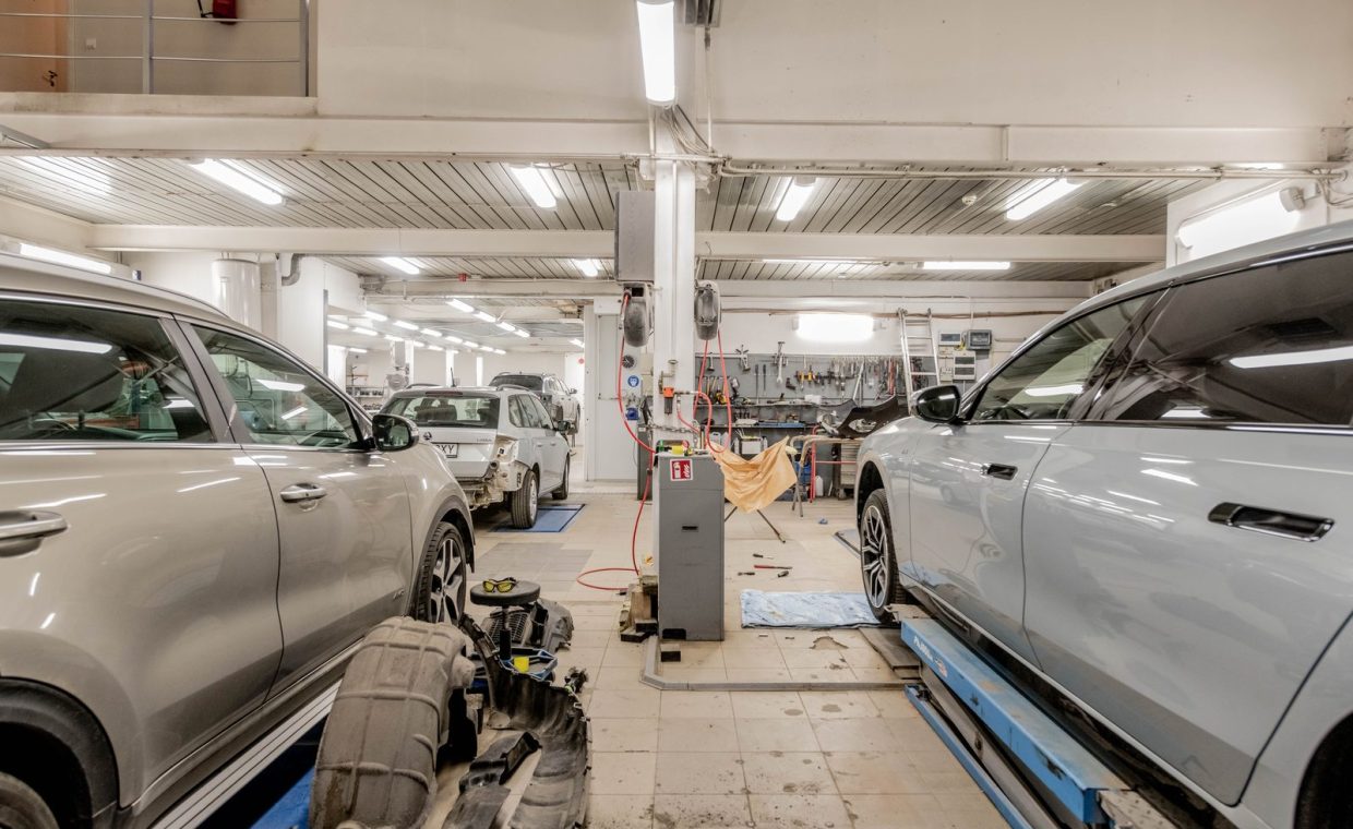 Interior of an automotive repair shop with cars undergoing maintenance and servicing.